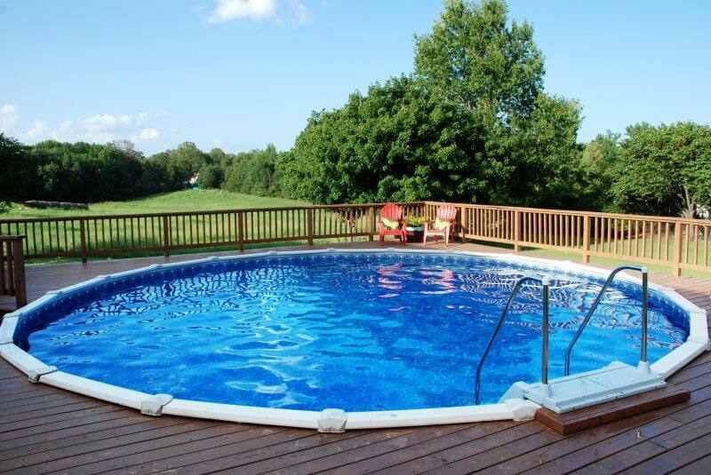 A beautiful backyard above-ground pool with a surrounding deck.