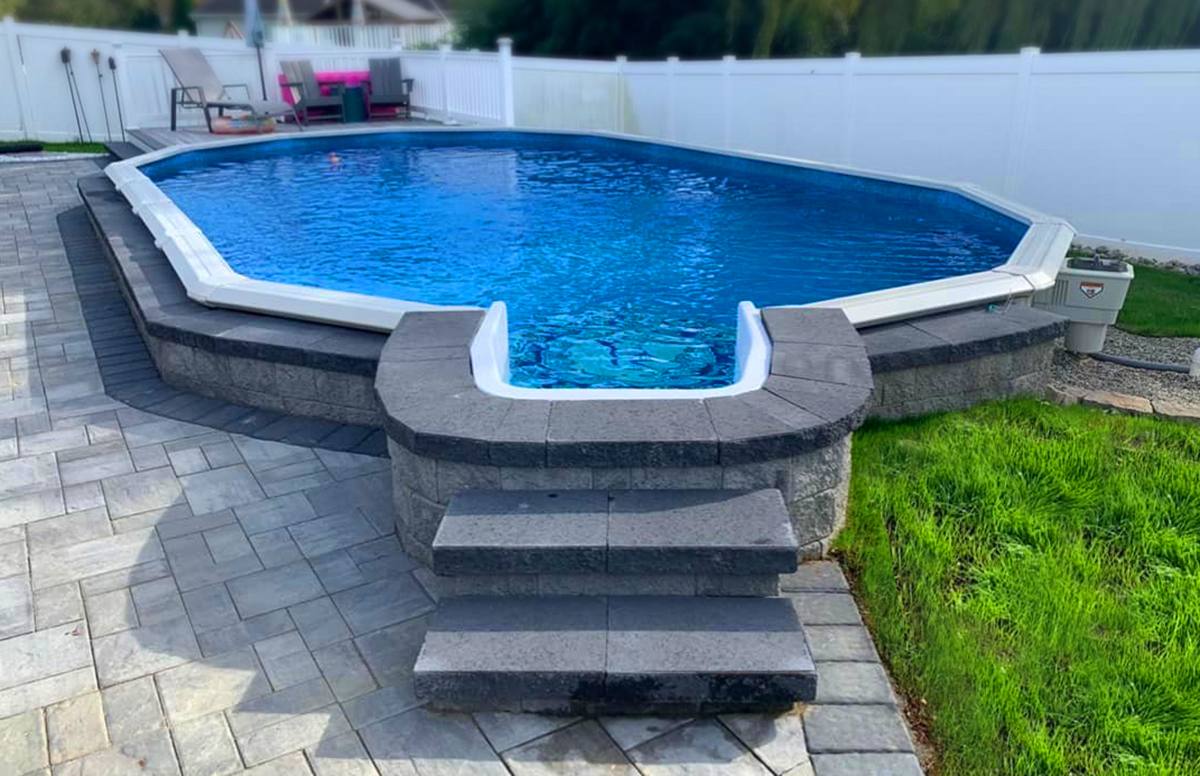 A doughboy above ground pool recessed into a stone patio