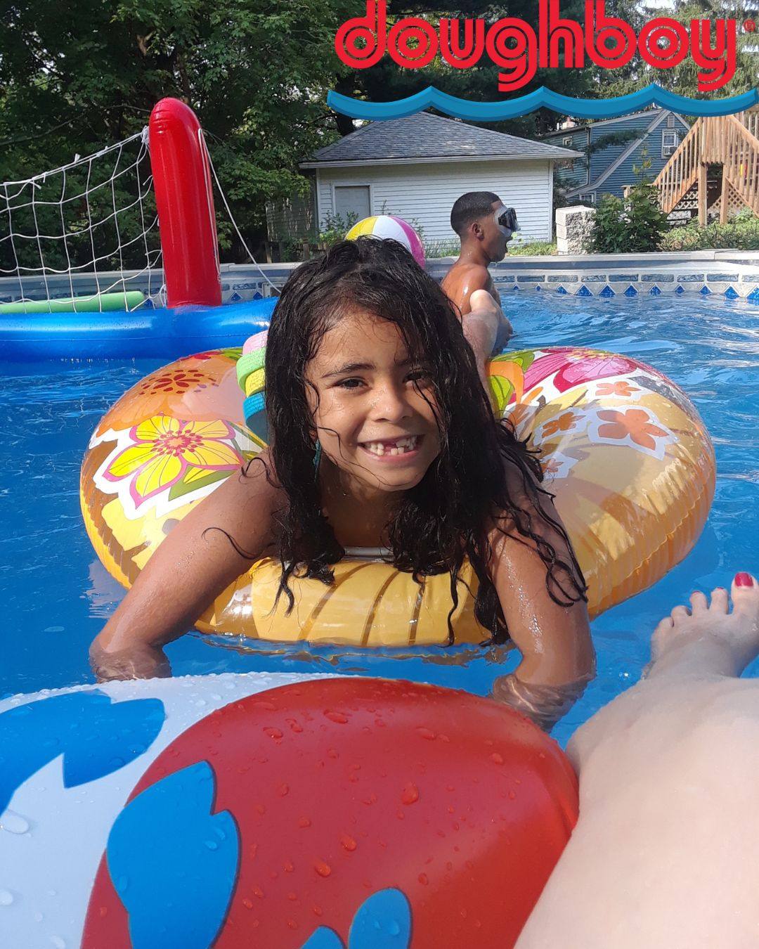 A girl is laying on a pool float in an above ground swimming pool.